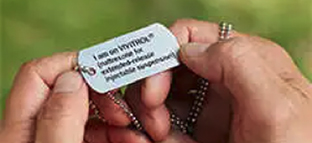 A patient holding a medical alert dog tag