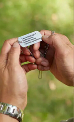 A patient holding a medical alert dog tag